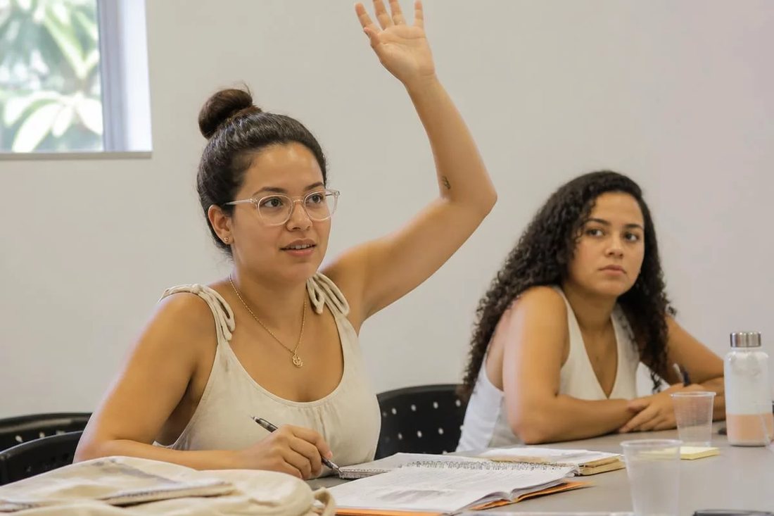 Facilitador em pé apontando para um argumento escrito no quadro durante a sessão